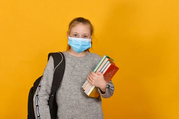 戴着防护面罩的女学生 手里拿着课本 隔离概念和家教 — 图库照片