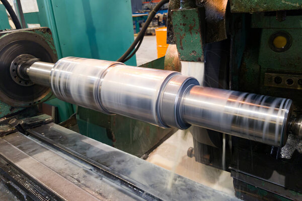 Processing and manufacturing of a shaft with an abrasive stone on a circular grinding machine, sparks are cooled by a liquid