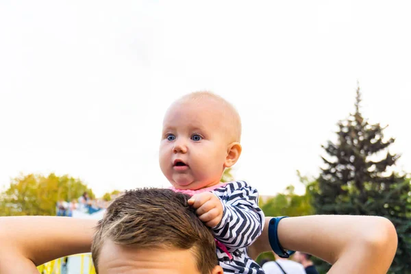 Uma Criança Pequena Senta Pescoço Seu Pai Uma Menina Alegre — Fotografia de Stock