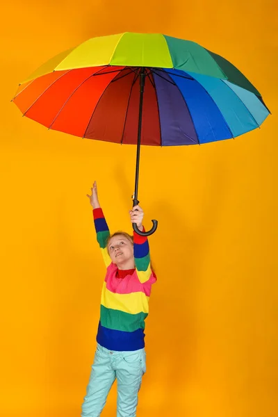 Dziewczyna Kolorowym Swetrze Trzyma Wielokolorowy Parasol Dłoni Żółtym Tle Dziecko — Zdjęcie stockowe