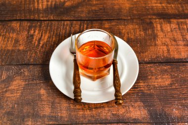 Bir bardak konyak tabakta durur, yemek yerine alkol, alkol bağımlılığı kavramı..