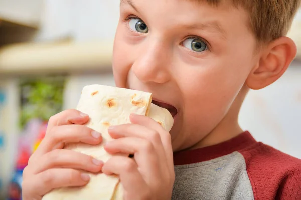 Мальчик Держит Шаурму Руках Ребенок Откусывает Мясо Завернутое Пита Хлеб — стоковое фото
