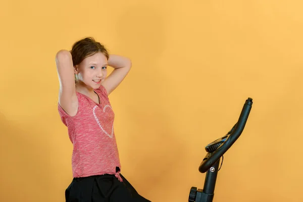 Menina Alegre Está Envolvida Uma Bicicleta Exercício Retrato Adolescente Estúdio — Fotografia de Stock