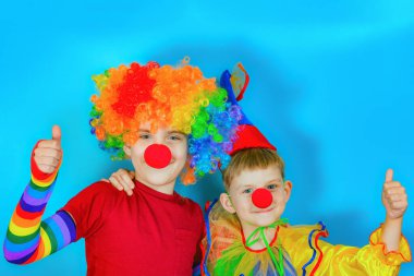Two clowns cuddle and put their thumbs up. clipart