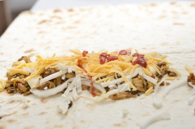 Neredeyse hazırlanmış shawarma beyaz bir masada yatıyor..