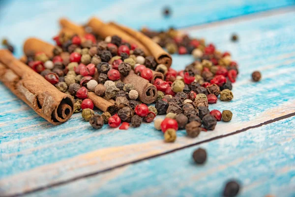 Spices and cinnamon lie in bulk on a blue wooden background