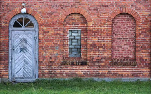 Bögen und Tür in einer Wand aus roten Ziegeln — Stockfoto