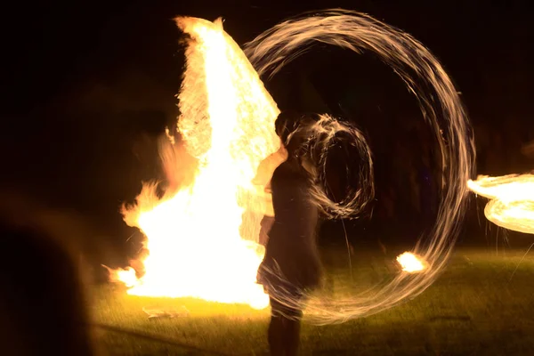 Lunga esposizione colpo di torce in movimento e fuoco con silhouette vaga di una persona — Foto Stock