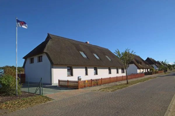 Thatched σπίτια στην Hanshagen, Μεκλεμβούργο-Δυτική Πομερανία, Γερμανία. Στα αριστερά η σημαία της Δυτικής Πομερανίας με τα εραλδικά ζώο, ο Γρύπας — Φωτογραφία Αρχείου