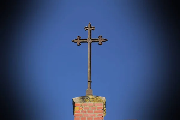 Christliches Metallkreuz auf einer Klinkerkirche — Stockfoto