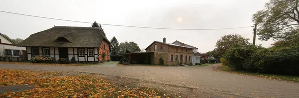 Lindenalle in Reinberg, Germany, with various historic buildings and faint sun creating a twilight mood — Stock Photo, Image