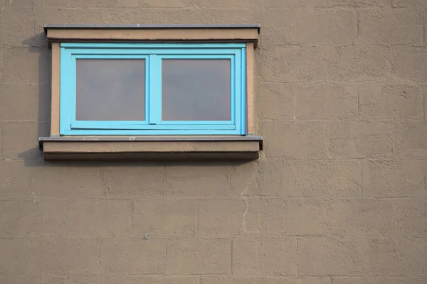 Modré okno na cihlovou zeď s šedou barvou — Stock fotografie