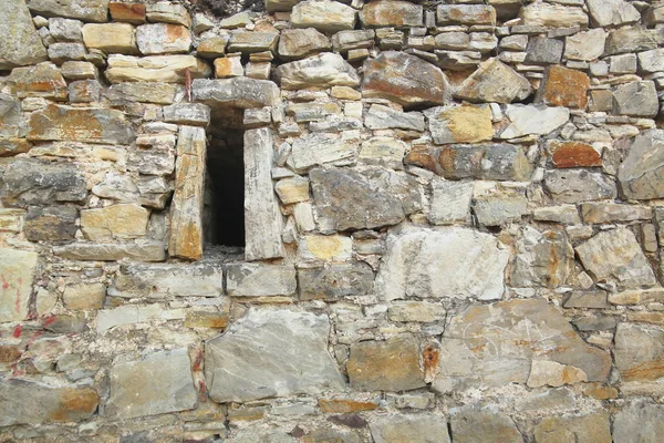 Irregular fieldstone wall with an arrow slit — Stock Photo, Image