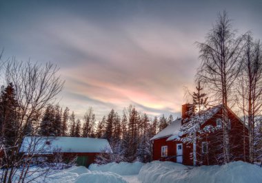 HDR image of nacreous clouds over typical Swedish buildings. clipart