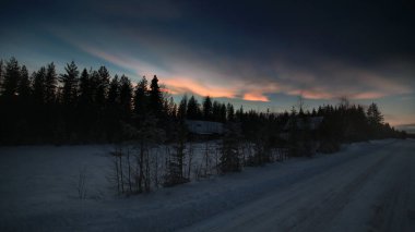 HDR image of nacreous clouds over Swedish farm buildings in winter. clipart