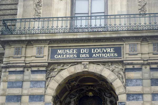 The building of the Louvre Museum with an inscription in French: Louvre Museum and the galleries of antiques exhibits. — Stock Photo, Image