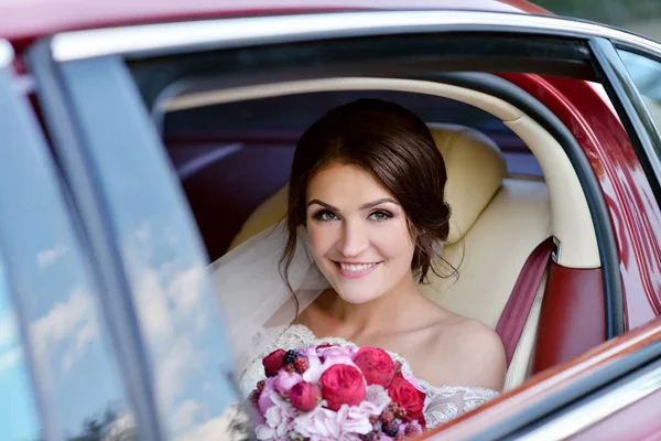Bruid met boeket in auto — Stockfoto