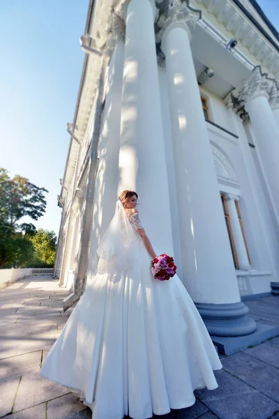Noiva em vestido branco com buquê — Fotografia de Stock