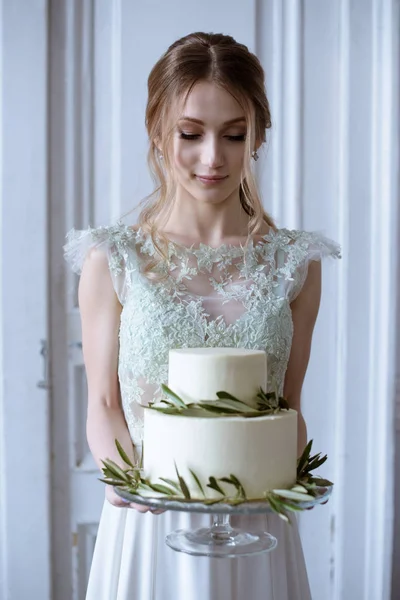 Bellezza sposa in abito da sposa con torta e velo di pizzo all'interno — Foto Stock