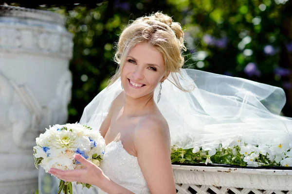 Belleza novia en vestido de novia con ramo y velo de encaje en la naturaleza —  Fotos de Stock