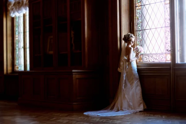 Belleza novia en vestido de novia con ramo y velo de encaje en el interior —  Fotos de Stock