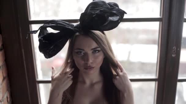 年轻美丽的模特在画室里摆着黑色蝴蝶结的头 — 图库视频影像