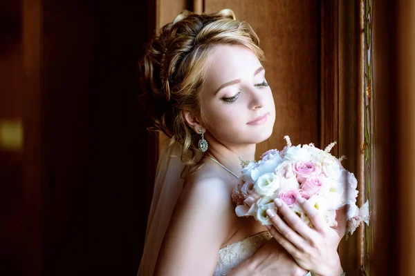 Krásu nevěsty ve svatební šaty s kytici a krajkový závoj uvnitř — Stock fotografie