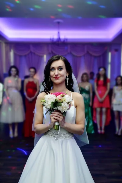 Belleza novia en vestido de novia con velo de encaje está lanzando ramo de boda en el interior —  Fotos de Stock