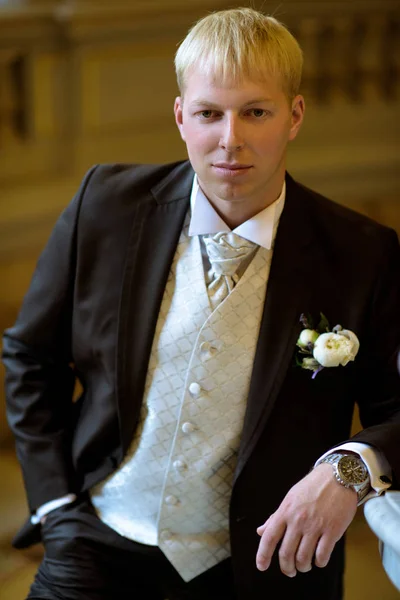 Stilig brudgummen i kostym i hallen — Stockfoto