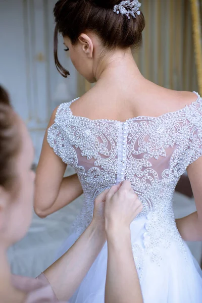 Koszorúslány a befűzési fehér esküvői ruha a gyönyörű menyasszony — Stock Fotó