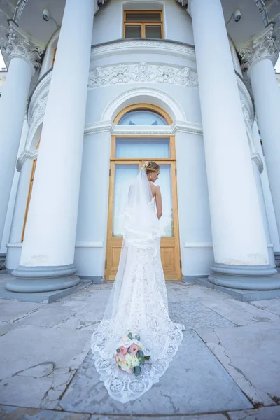 Noiva de beleza em vestido de noiva com buquê e véu de renda na natureza — Fotografia de Stock