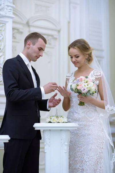 Belleza novia y novio guapo están usando anillos entre sí — Foto de Stock