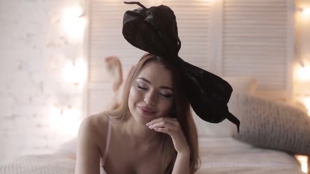 頭にリボン付きのランジェリーのスタジオでポーズをとってセクシーな女性モデル — ストック動画