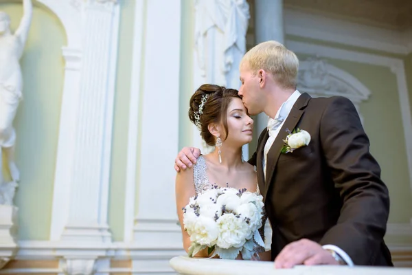 Pareja de boda en el interior es abrazarse entre sí — Foto de Stock