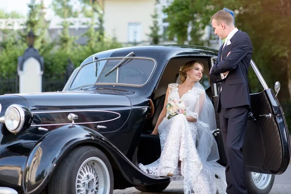 Wedding couple is hugging each other near a car — Stock Photo, Image