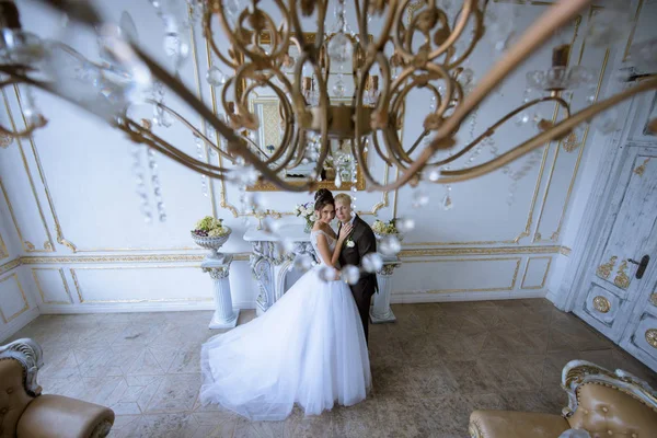 Bröllopsparet inomhus kramar varandra — Stockfoto