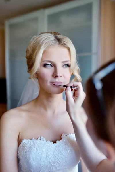 Artista de maquiagem de casamento fazendo uma maquiagem para a noiva — Fotografia de Stock