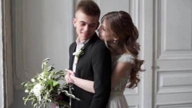 Genç ve güzel gelin ve damat stüdyoda poz veriyor.