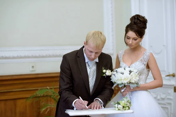 Schoonheid bruid en knappe bruidegom zijn de registratie van het huwelijk — Stockfoto