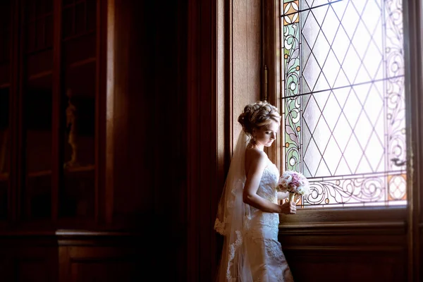 Belleza novia en vestido de novia con ramo y velo de encaje en el interior —  Fotos de Stock