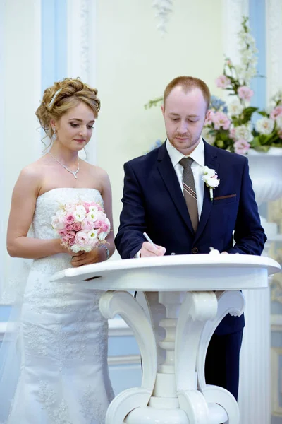 Beauty bride and handsome groom are registering the marriage — Stock Photo, Image