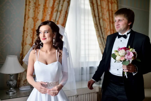 Schöner Bräutigam sieht morgens zuerst die schöne Braut — Stockfoto