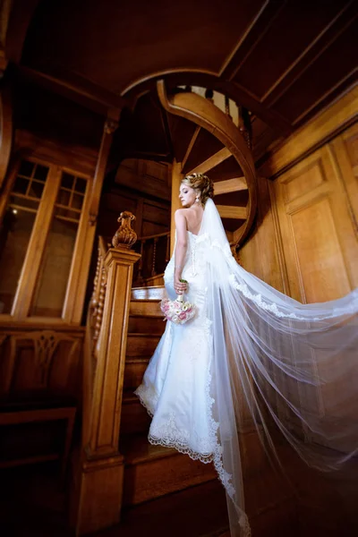 Schönheit Braut im Brautkleid mit Strauß und Spitzenschleier drinnen — Stockfoto