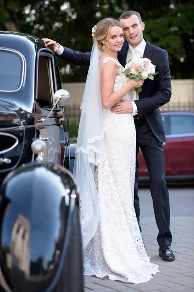 Çift düğün birbirlerine sarılıyor bir araba — Stok fotoğraf