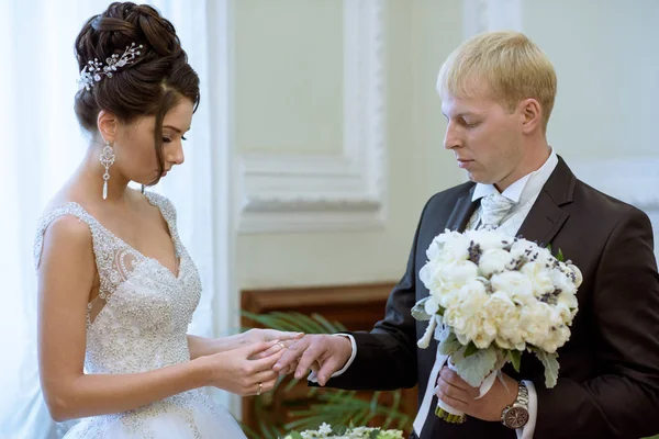 Belleza novia y novio guapo están usando anillos entre sí —  Fotos de Stock