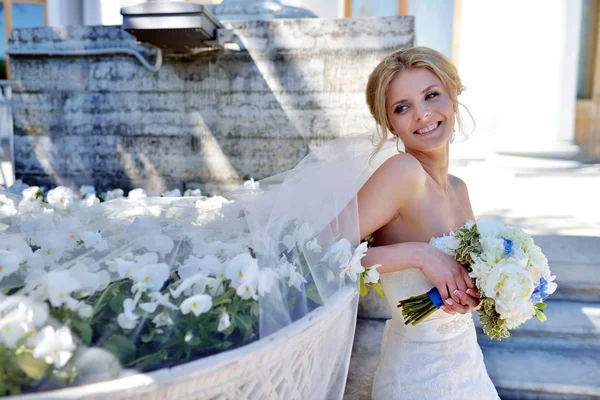 Belleza novia en vestido de novia con ramo y velo de encaje en la naturaleza —  Fotos de Stock