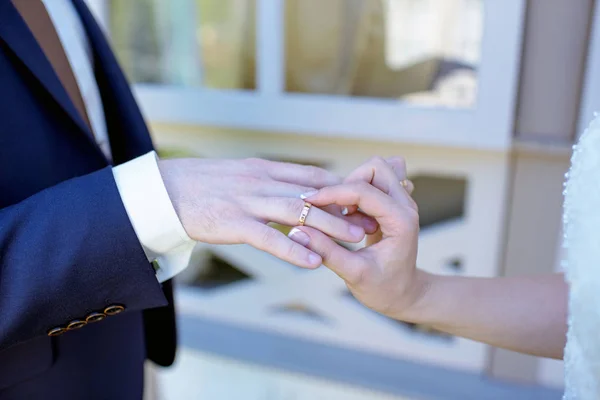 Pengantin wanita cantik dan pengantin pria tampan memakai cincin satu sama lain — Stok Foto