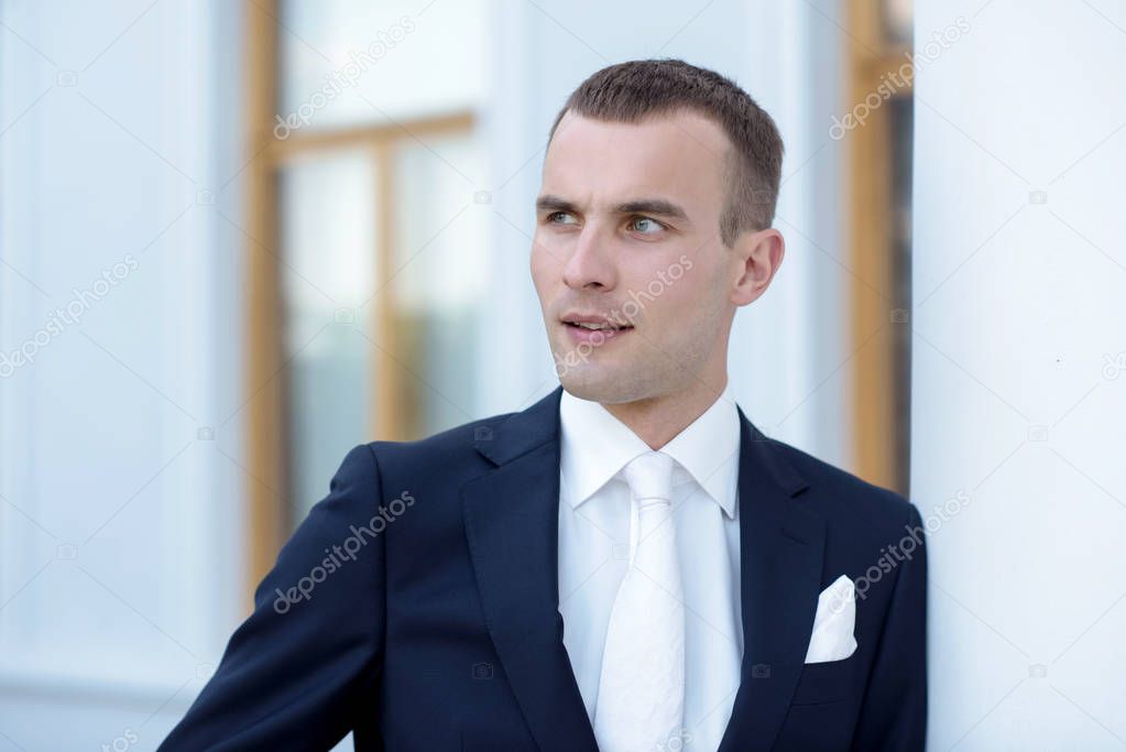 Handsome groom in suit in the nature