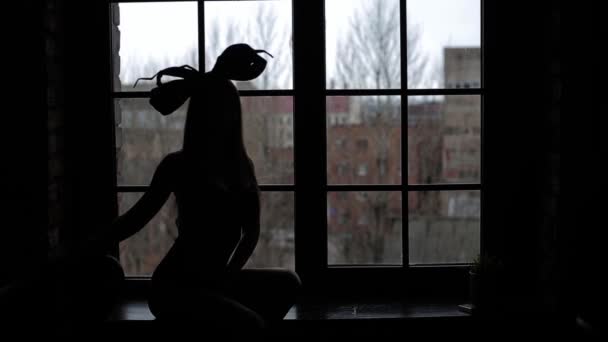 ランジェリー黒弓の頭の上のスタジオでポーズをとる若い美しいモデル — ストック動画