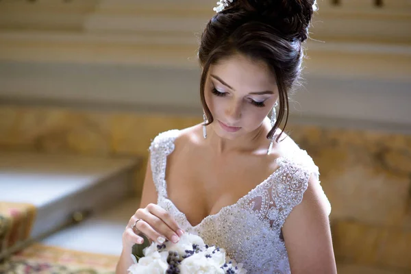 Schoonheid bruid in bruidsjurk met boeket en kantpatroon sluier binnenshuis — Stockfoto